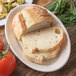 A Carlisle bone oval platter with sliced bread and tomatoes on it.