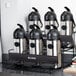 A Bunn two tier universal airpot rack holding six coffee containers.