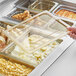 A hand placing a Cambro H-Pan lid on a food container.
