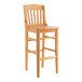 A Lancaster Table & Seating wooden school house bar stool with a wooden seat.