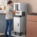 A woman using a Hoshizaki ice machine and water dispenser stand.