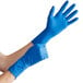 A person wearing blue High Risk Latex Exam gloves.