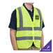 A man wearing a lime green high visibility safety vest.
