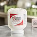 A white container with a red label for Noble Chemical Power Block solid dish machine detergent.