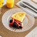 A WNA Comet clear plastic plate with a slice of pie and a fork on a table.
