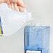 a person pouring a liquid into a jug