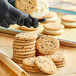 A person holding a JOY chocolate chip cookie.