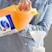 A person pouring Dial Gold antibacterial hand soap into a funnel.