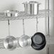 A metal rack with Choice aluminum cookware set on it.