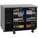 A black Turbo Air back bar cooler with glass doors filled with beer bottles.