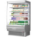 A Turbo Air stainless steel vertical open display case filled with drinks and beverages.