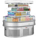 A Turbo Air stainless steel oval island display case with drinks on it.