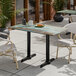 A rectangular standard height table with a textured canyon painted faux metal finish and end base plates.
