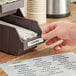 A hand putting adhesive labels on a flatware organizer.