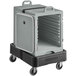 A slate blue plastic CaterGator front loading container on a black dolly with a black strap.