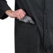 A man wearing a black Cordova rain coat holding a knife in his pocket.