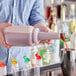 A person using a Choice pour bottle to pour liquid into a cup.