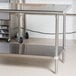 An Advance Tabco stainless steel work table with undershelf.