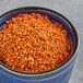 A bowl of Tajin Classic Seasoning on a table.