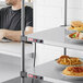 A man sitting at a table with a cheeseburger and fries from a Metro heated shelf.