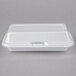 A white styrofoam container with a hinged lid.
