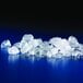A pile of flake ice from a Manitowoc air cooled ice machine on a blue surface.