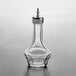 A Barfly clear glass bitters bottle with a metal top.