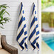 Two Monarch Brands navy towels with yellow stripes hanging on a wall.