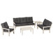 A white and grey POLYWOOD Vineyard deep seating set with black cushions on a white table.