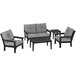 A grey POLYWOOD outdoor furniture set with black accents including a table, chairs, and a couch.