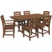 A POLYWOOD teak farmhouse table with six chairs on an outdoor patio.