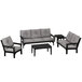 A black and grey POLYWOOD outdoor patio set with a couch and table.