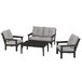 A black POLYWOOD table with grey cushions on a chair.
