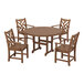 A round brown POLYWOOD dining table with four arm chairs around it on an outdoor patio.