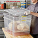 A man holding an Araven clear plastic food drain box with chicken inside.