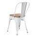 A white Lancaster Table & Seating metal chair with a wooden seat.