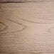 A close-up of a wood surface with gray wood grain and some scratches.