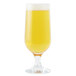 An Anchor Hocking stemmed Pilsner glass full of yellow beer with foam.