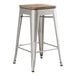 A Lancaster Table & Seating silver metal backless counter height stool with a gray wood seat.