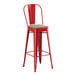 A red metal Lancaster Table & Seating barstool with a gray wood seat.