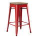 A Lancaster Table & Seating red metal backless counter height stool with a gray wood seat.