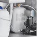 A white container with a black and silver tank and hoses inside.