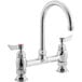a silver faucet with red knobs
