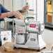A person using the Estella electric hard cheese grater to shred cheese.
