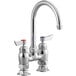 A silver Waterloo deck-mount faucet with two red knobs.