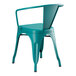 A teal metal arm chair with a backrest on a teal metal table.