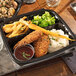 A black Pactiv Earthchoice plastic tray with mashed potatoes, chicken, and vegetables.