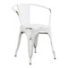 A white metal Lancaster Table & Seating chair with brown legs.