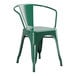 A Lancaster Table & Seating green metal arm chair.