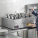 A woman serving food from a ServIt countertop food warmer.